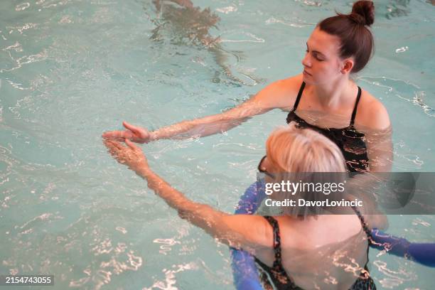 parkinson disease patient exercises with foam swimming tube, as disease therapy - parkinsons exercise stock pictures, royalty-free photos & images