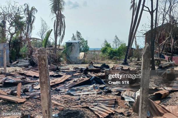 This photo taken on May 21, 2024 shows a destroyed house and burned trees following fighting between Myanmar's military and the Arakan Army ethnic...