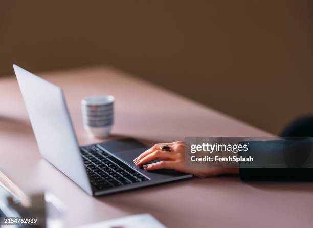 professional woman typing on laptop at modern workspace - inzoomen stockfoto's en -beelden