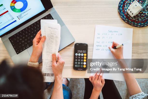 a direct above and personal perspective shot of mother and daughter managing home budget at home with the aid of a.i. financial app at home. - investment stock pictures, royalty-free photos & images