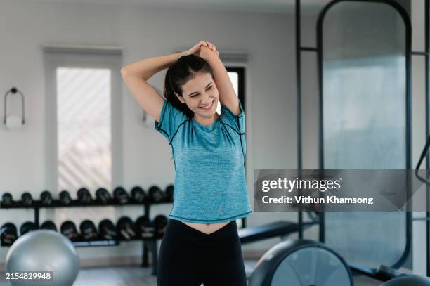 young woman exercising in the gym. - warm up exercise stock pictures, royalty-free photos & images