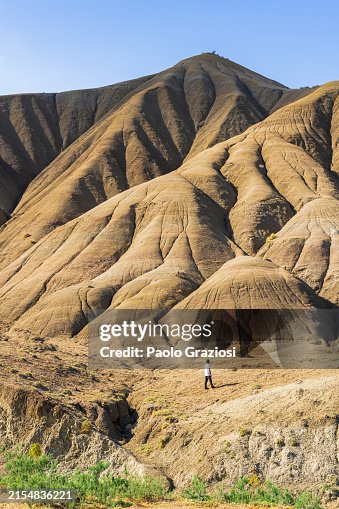Hiker walks through bizarre rock formation, Sicily Hiker walks through bizarre rock formation, Sicily