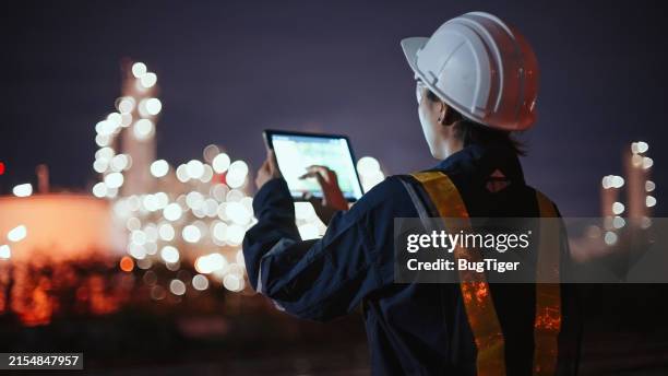 asian inspection engineers working with laptop of gas refinery plant and refinery oil factory industry at night. - essence photos et images de collection