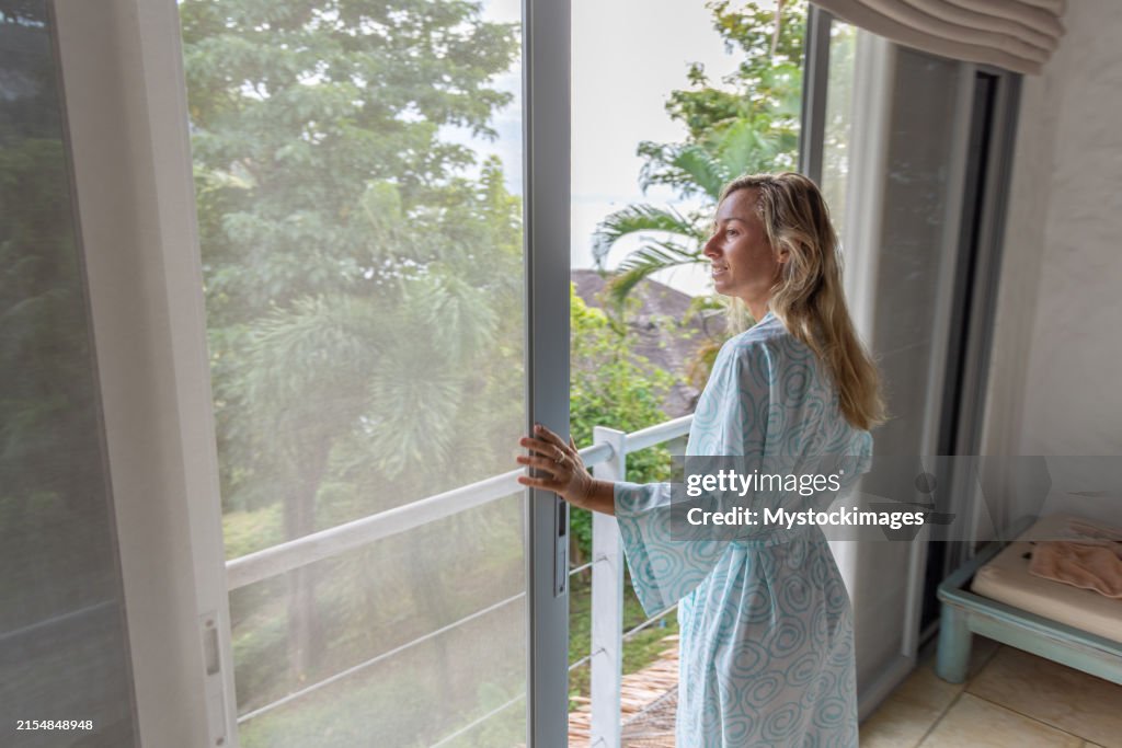 Happy woman enjoying a beautiful view from her balcony