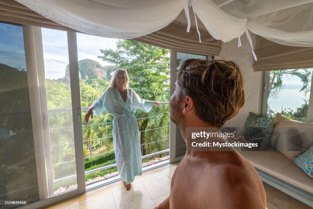 Couple enjoying tropical view from bedroom balcony