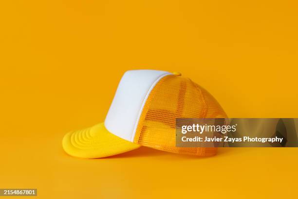 yellow cap isolated on yellow background - casquette de baseball photos et images de collection