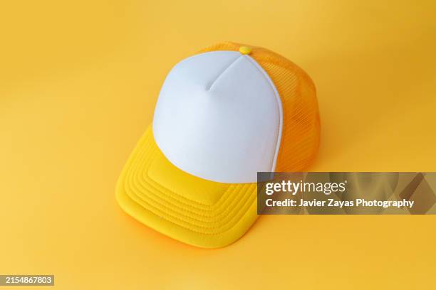 yellow cap isolated on yellow background - cap hat stock pictures, royalty-free photos & images