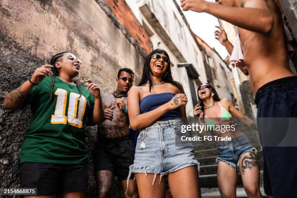 friends having fun dancing in the alley on favela in brazil - funk music stock pictures, royalty-free photos & images