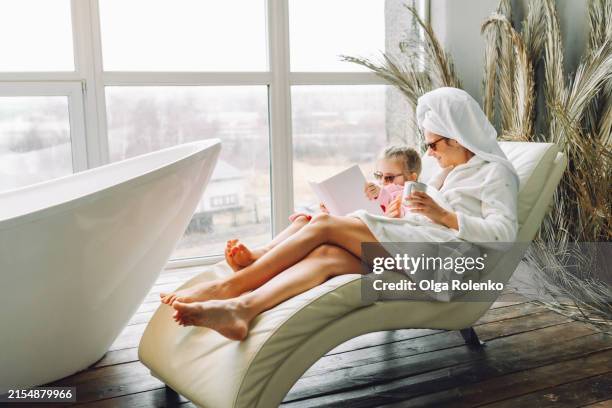 family choosing spa treatments: mother and daughter in sunglasses at spa relaxing on lounges - mom daughter spa day stock pictures, royalty-free photos & images