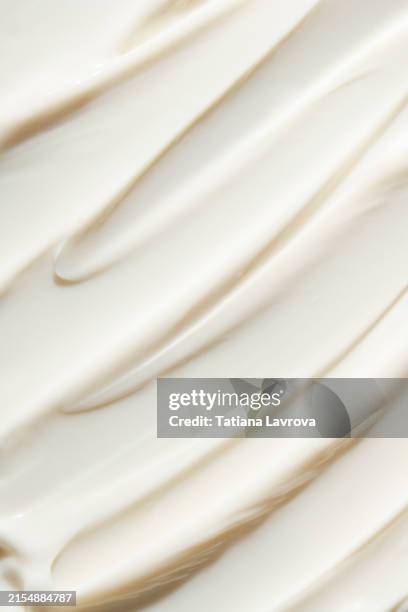 smears of white face cream in macro. close up of beauty product for face and body with copy space - crema foto e immagini stock