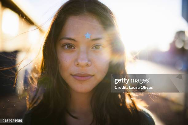 backlit portrait of teenage girl in her neighborhood wearing a pimple patch - pimple stock pictures, royalty-free photos & images