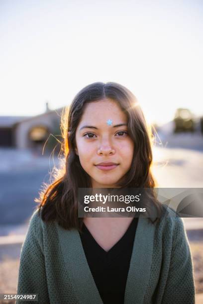 backlit portrait of teenage girl in her neighborhood wearing a pimple patch - of beautiful latinas stock pictures, royalty-free photos & images