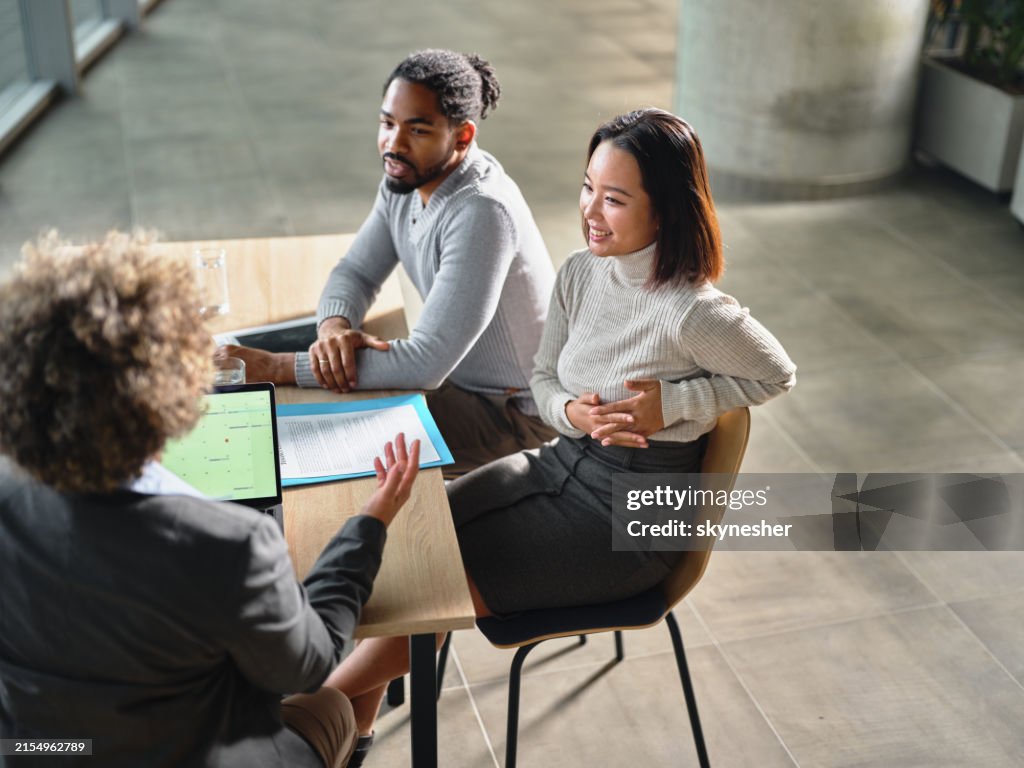 Happy diverse couple having a meeting with their agent in the office.