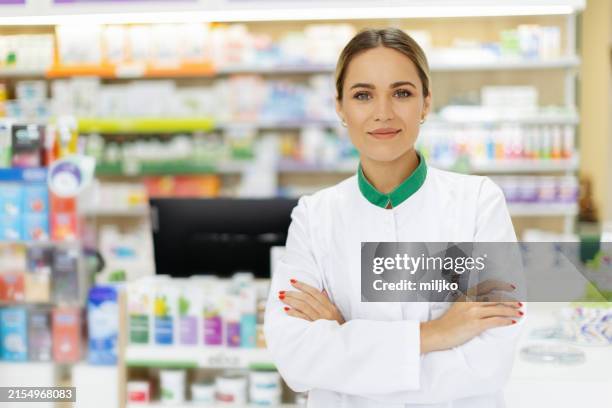 junge apothekerin an ihrem arbeitsplatz - apothekerin stock-fotos und bilder