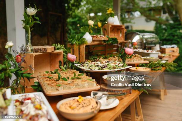 buffet-essen für die party mit frischen pflanzen dekoriert. - anrichte stock-fotos und bilder