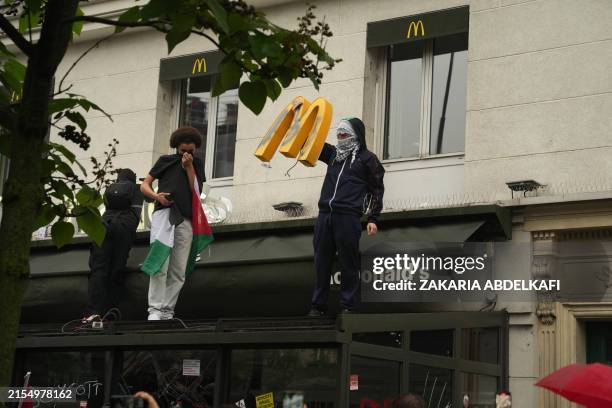Rioting demonstrator holds a logo of a McDonald's fast food restaurant after the restaurant was ransacked within a demonstration called by Kanak...