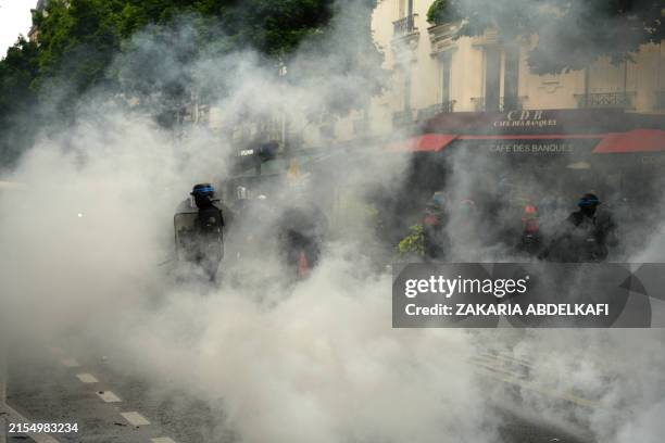 Anti-riot police officers stand amid teargas as they secure a street after clashes erupted within a demonstration called by "Urgence Palestine"...