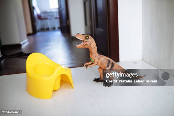potty training with dinosaur toy, learning to use the toilet - potty training stock pictures, royalty-free photos & images