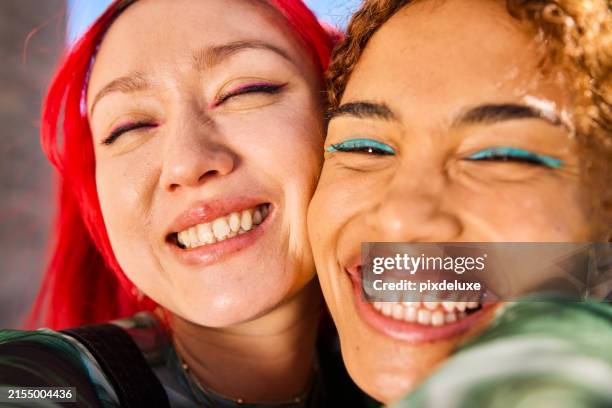 close-up of two gen z adults smiling and laughing outdoors. urban environment. friendship and well-being. - eye make up stock pictures, royalty-free photos & images
