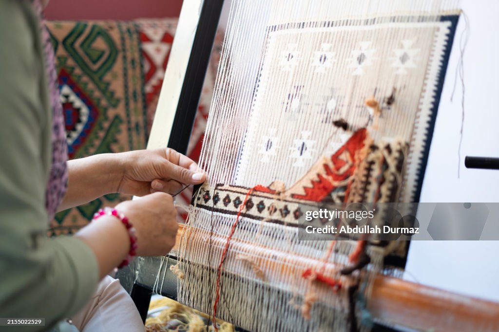 Close-up Adult woman's hands produce rugs in the workshop
