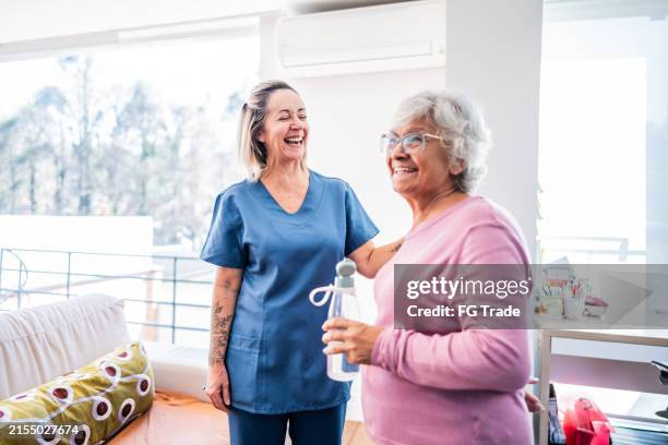 mujer mayor feliz y fisioterapeuta en casa - prevención de enfermedades fotografías e imágenes de stock
