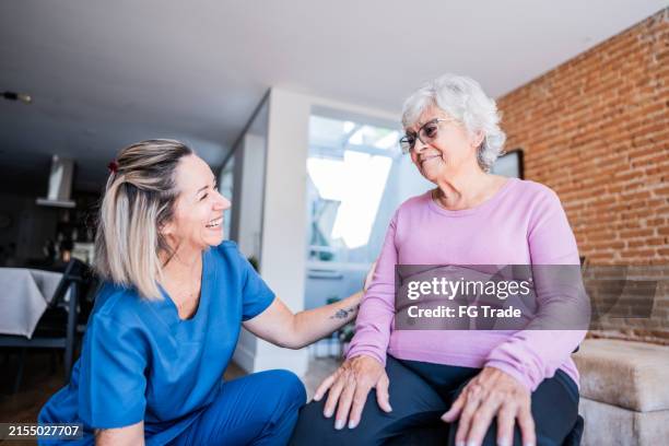 physical therapist helping senior woman at home - terapia ocupacional imagens e fotografias de stock