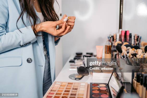 maquilladora preparando pestañas postizas para una clienta en un salón de belleza - maquillador fotografías e imágenes de stock