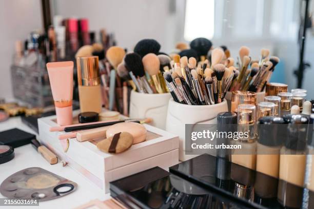 un set di pennelli per il trucco e prodotti di bellezza disposti su una scrivania nel salone dell'estetista - pennello-da-trucco foto e immagini stock
