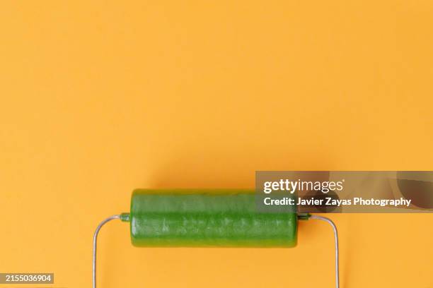 green capacitor isolated on yellow background - condenser stock pictures, royalty-free photos & images