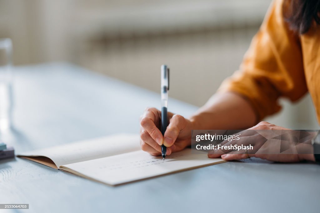 Person With Notebook Person Writing In Notebook At A Light Blue Desk High-Res Stock Photo ...