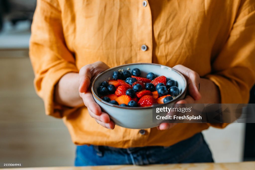 Person Holding Bowl Of Fresh Strawberries And Blueberries