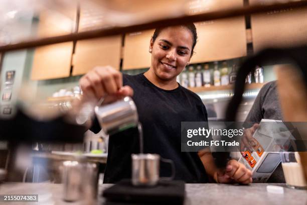 cafeteria worker preparing a coffee at cafeteria - barista stockfoto's en -beelden