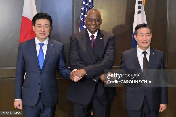 Japan's Defence Minister Minoru Kihara, US Defence Secretary Lloyd Austin and South Korea's Defence Minister Shin Won-sik attend a trilateral meeting...