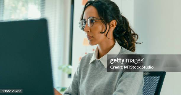 female professional data scientist intently working on laptop in modern office. software developer, artificial intelligence and programming. - java code stock pictures, royalty-free photos & images