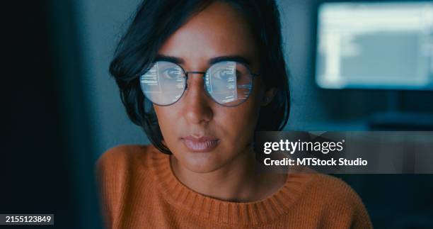 female computer programmer works on complex software development tasks at her home office late into the night. software developer, artificial intelligence and programming. - lunettes de vue photos et images de collection