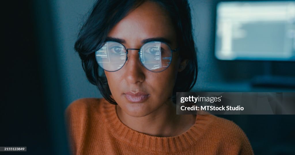 Female computer programmer works on complex software development tasks at her home office late into the night. Software developer, artificial intelligence and programming.