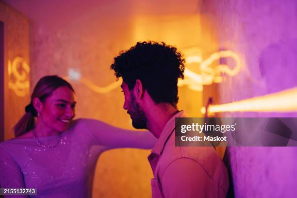 romantic couple enjoying with each other near illuminated wall - atividade romântica - fotografias e filmes do acervo