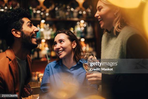 cheerful male and female friends having fun at bar - counter stock pictures, royalty-free photos & images