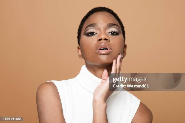 fashion model posing against beige background - short hair stock pictures, royalty-free photos & images