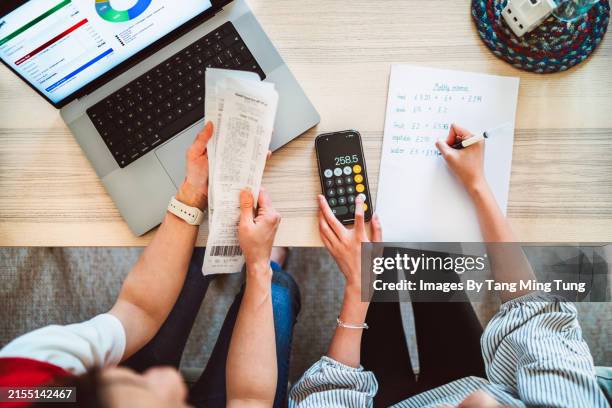 direct above shot of asian mom and daughter learning finance together at home - home finances stock pictures, royalty-free photos & images
