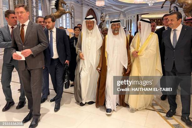 Russia's Energy Minister Alexander Novak and his counterparts from Saudi Arabia Prince Abdulaziz bin Salman and the UAE's Suhail Al-Mazroui walk out...