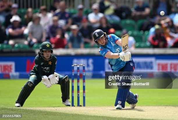 Heather Knight of England plays a shot as Pakistan wicket keeper Najiha Alvi looks on during the 3rd Women's Metro Bank ODI between England and...