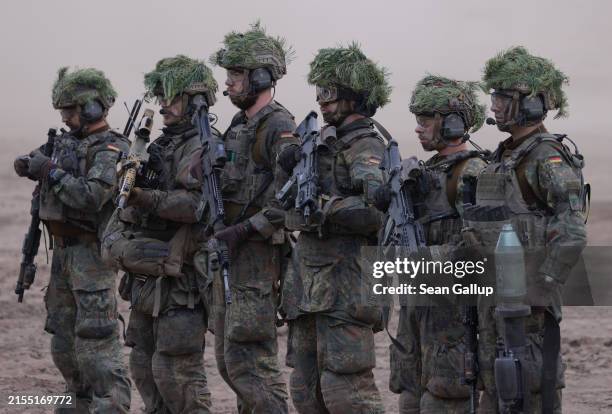 Troops of the Bundeswehr, the German armed forces, stand with their weapons at the Quadriga military exercises involving German, French, Lithuanian...