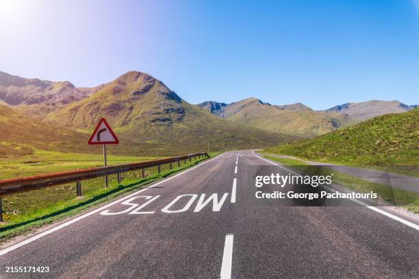 turn sign and slow on an asphalt road in nature - lentezza foto e immagini stock