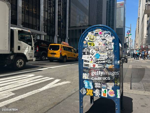 Post Office mailbox covered in stickers and graffiti on sixth avenue, Manhattan, New York.