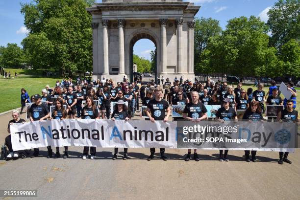 Protesters hold a 'National Animal Rights Day' banner during the demonstration. Animal rights activists gathered with pictures of animals next to the...