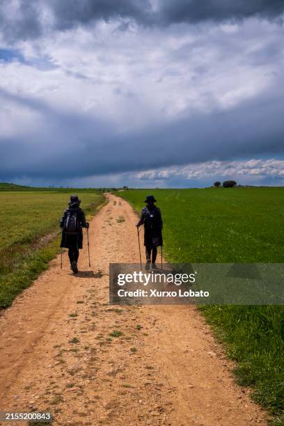 Two women pilgrims arriving at the village, on April 28, 2024 in Castrojeriz, Burgos, Spain. The Camino de Santiago is an ancient pilgrimage route...