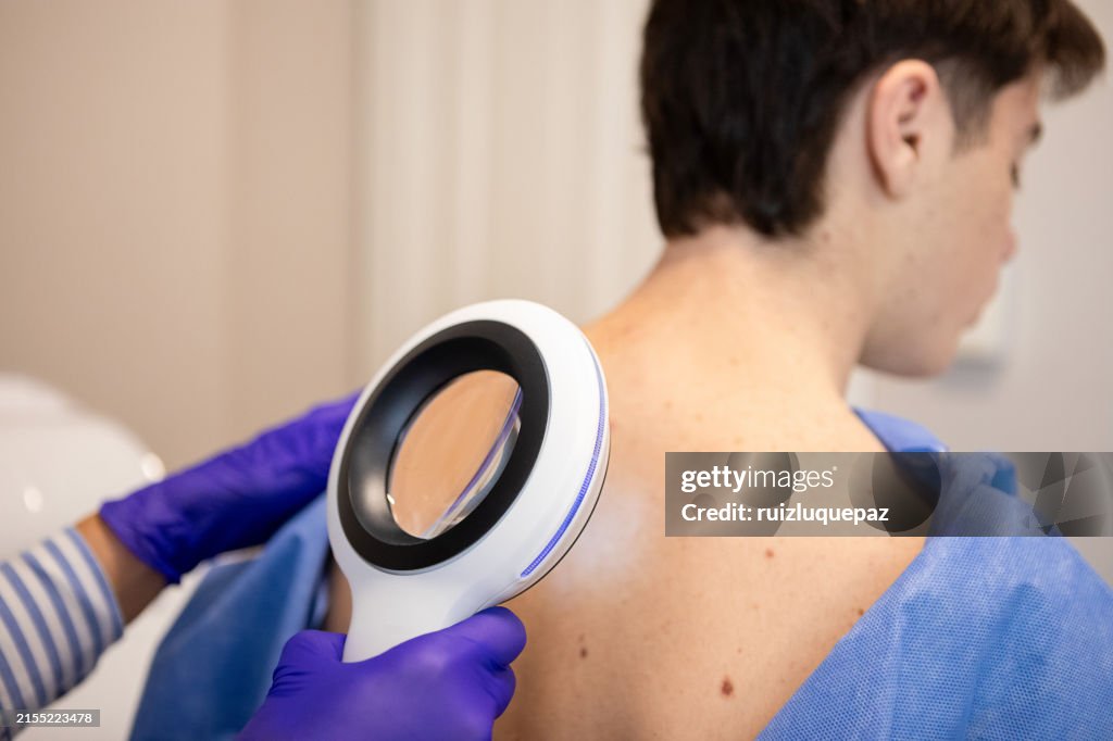 Dermatologist examining her patient with a dermatological magnifying glass