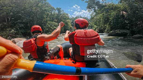 point of view asian rafters running the rapids, rafting on whitewater river, southeast asia - white water rafting stock pictures, royalty-free photos & images