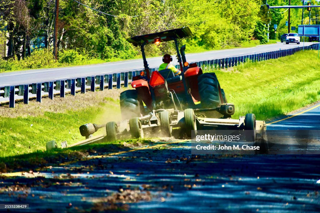 L'uomo falcia l'erba incolta sull'autostrada, contea di Fairfax, Virginia (USA)